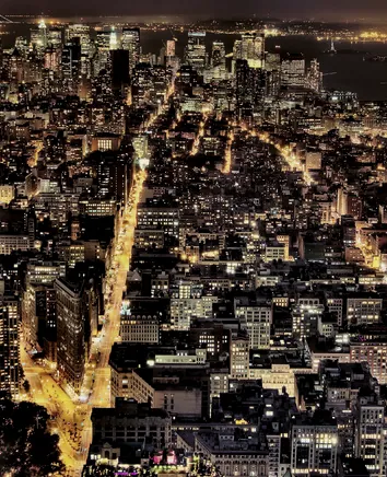 A dense city grid lit at night, seen from above