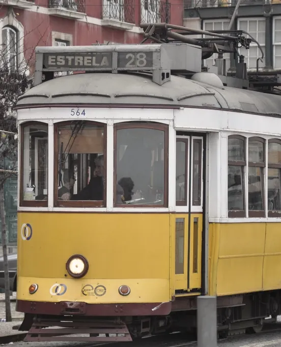 A yellow tram waiting at a corner