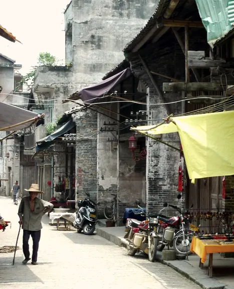 A narrow lane of shopfronts in morning light