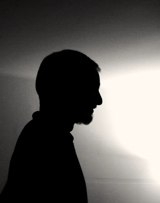A profile silhouetted against a bright window