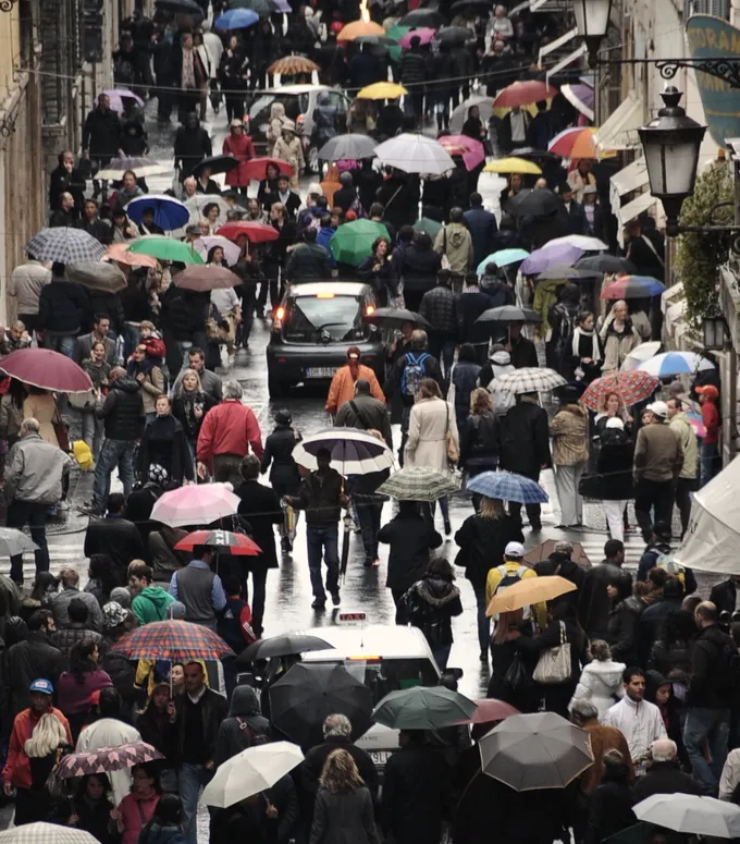 A crowd of umbrellas filling a street, seen from above