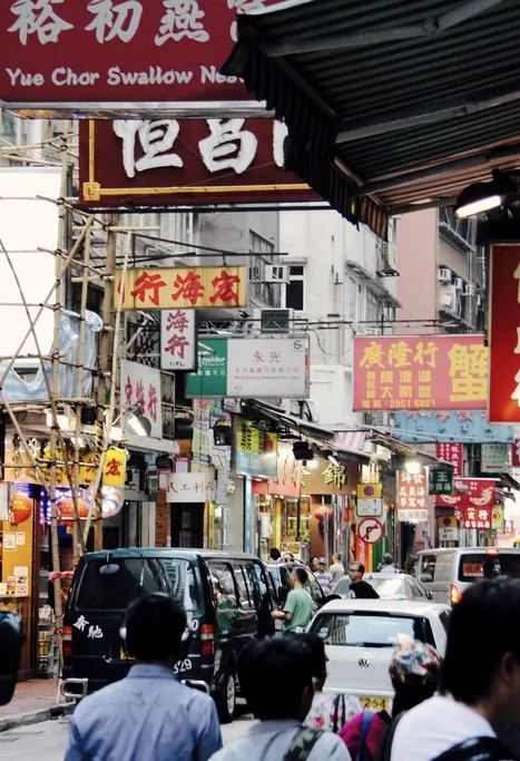 A crowd moving beneath dense shop signs