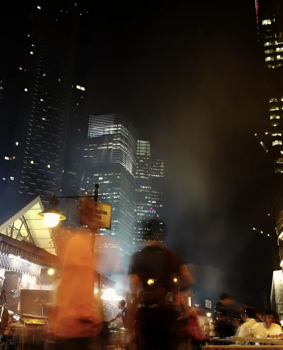 Food stalls glowing on a city street at night