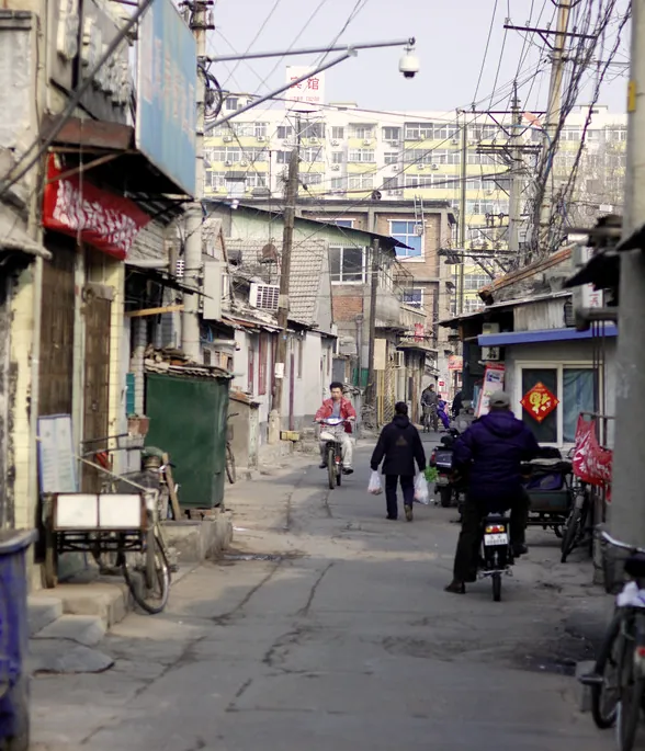 Figures walking a narrow back lane