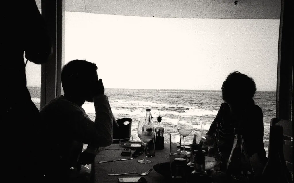 Two figures silhouetted against a bright window